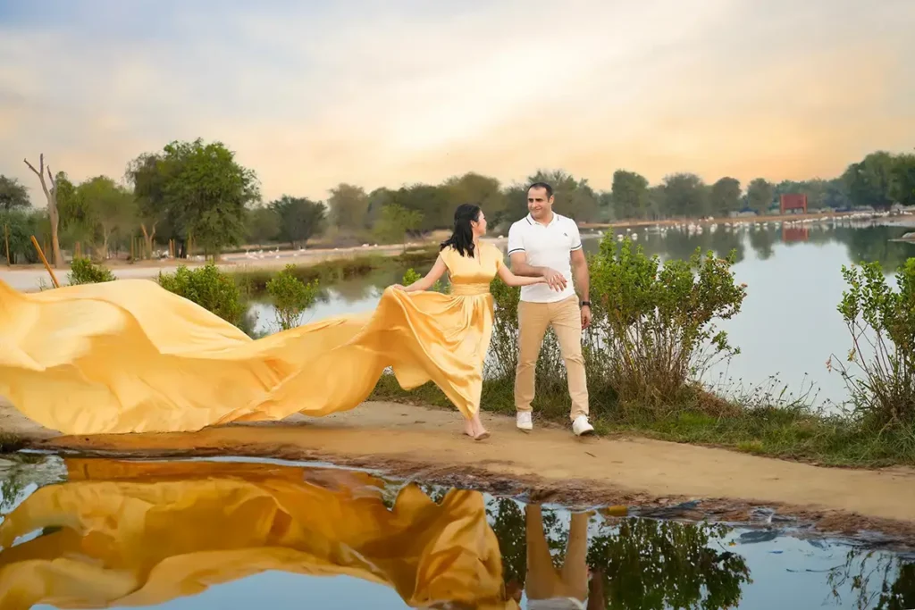 a man and woman in yellow dress by water