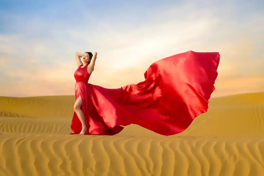 a woman in a red dress in a desert