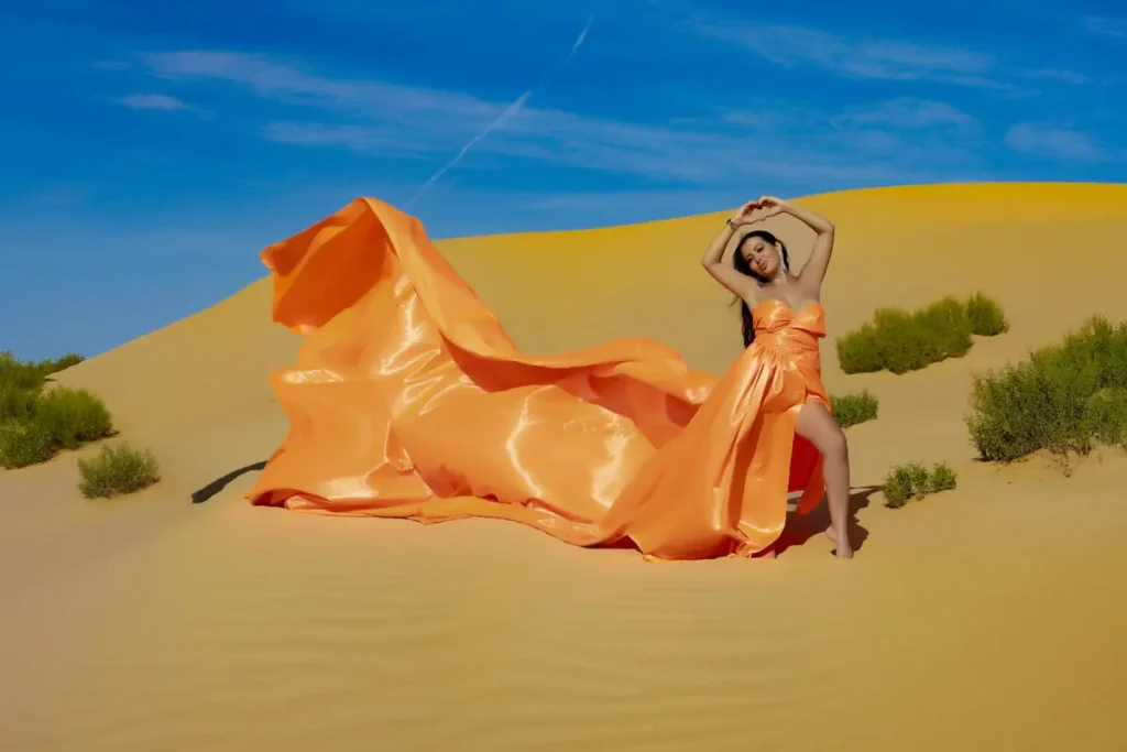 a woman in an orange dress in a desert