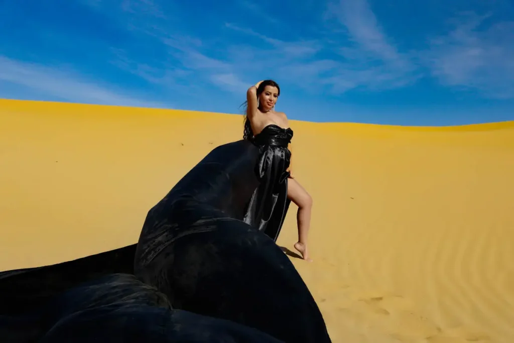 a woman in a black dress in a desert