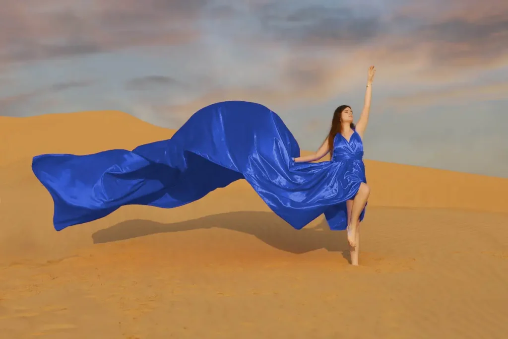 a woman in a blue dress in the desert